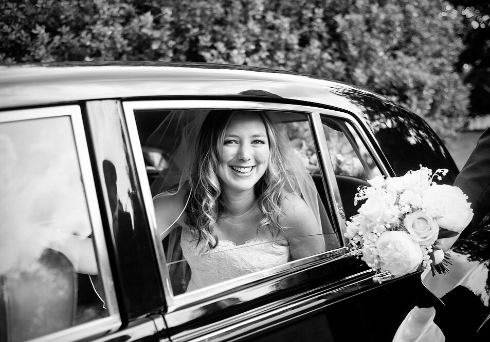 Bride looking out of a vintage car window